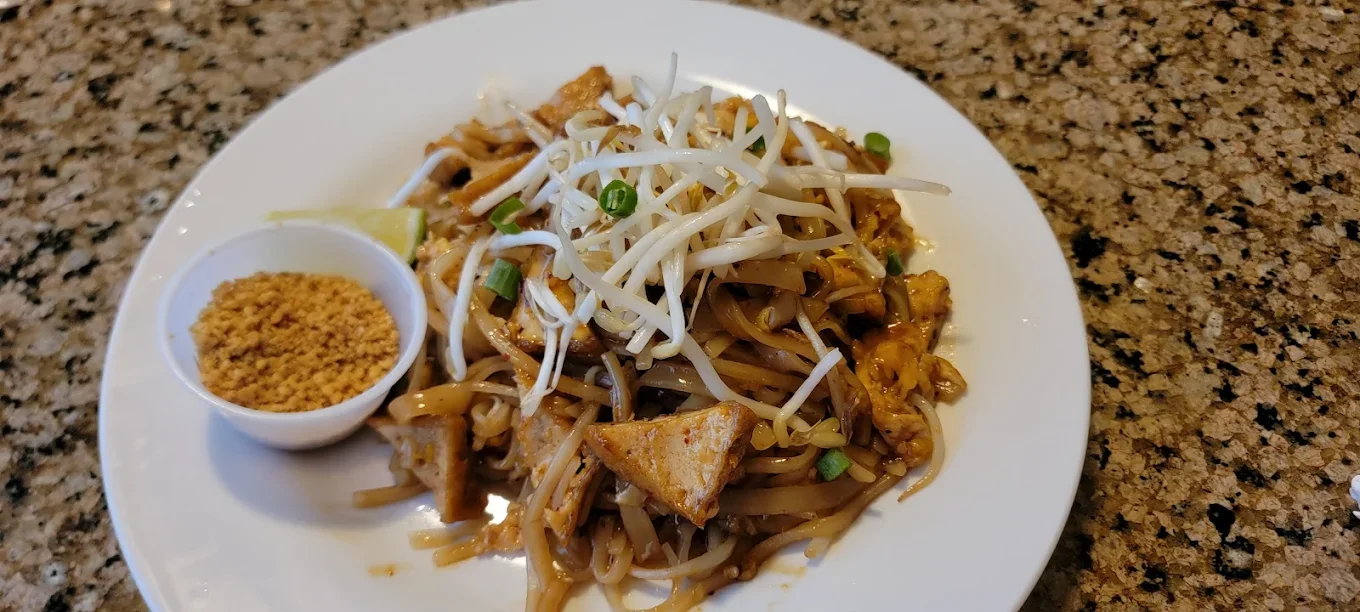 Pad Thai - Our signature stir-fried rice noodles with egg, bean sprouts, green onions, and your choice of protein, topped with crushed peanuts and lime.